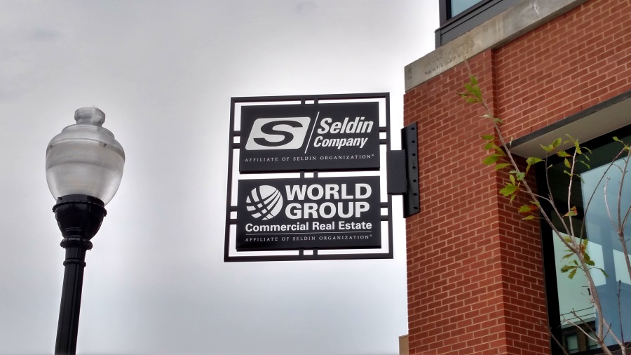 Non-illuminated, double-face Seldin Company and World Group projecting sign located downtown